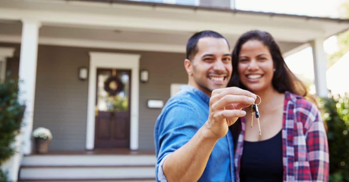 House Registration - Couple showing off their keys to their new home