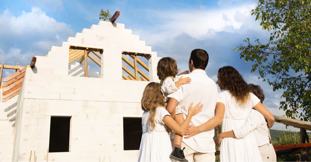 Family standing in front of a new house they are having built