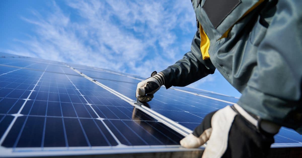 Worker installing solar panels on a rooftop in Cape Town for renewable energy.