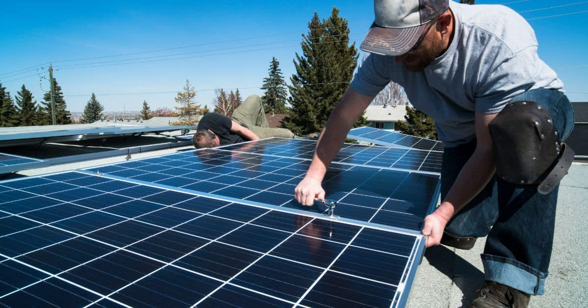 Team adjusting solar panels on roof