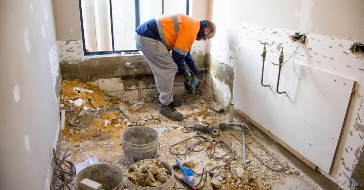 Skilled worker renovating a bathroom with demolition tools in Cape Town.