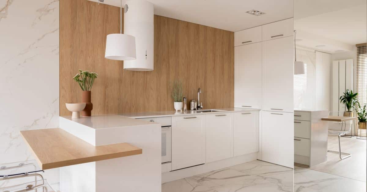 Bright minimalist kitchen with white cabinets and wooden accents.