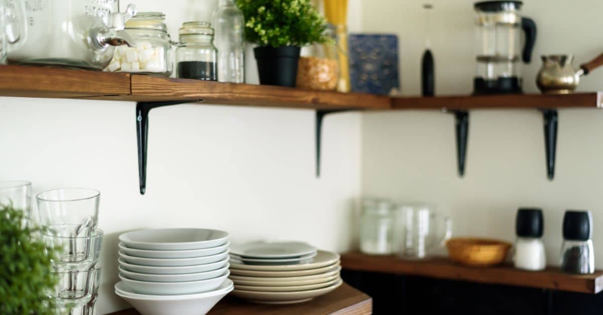 Shelf with plates, glasses, and kitchen essentials in a contemporary kitchen.