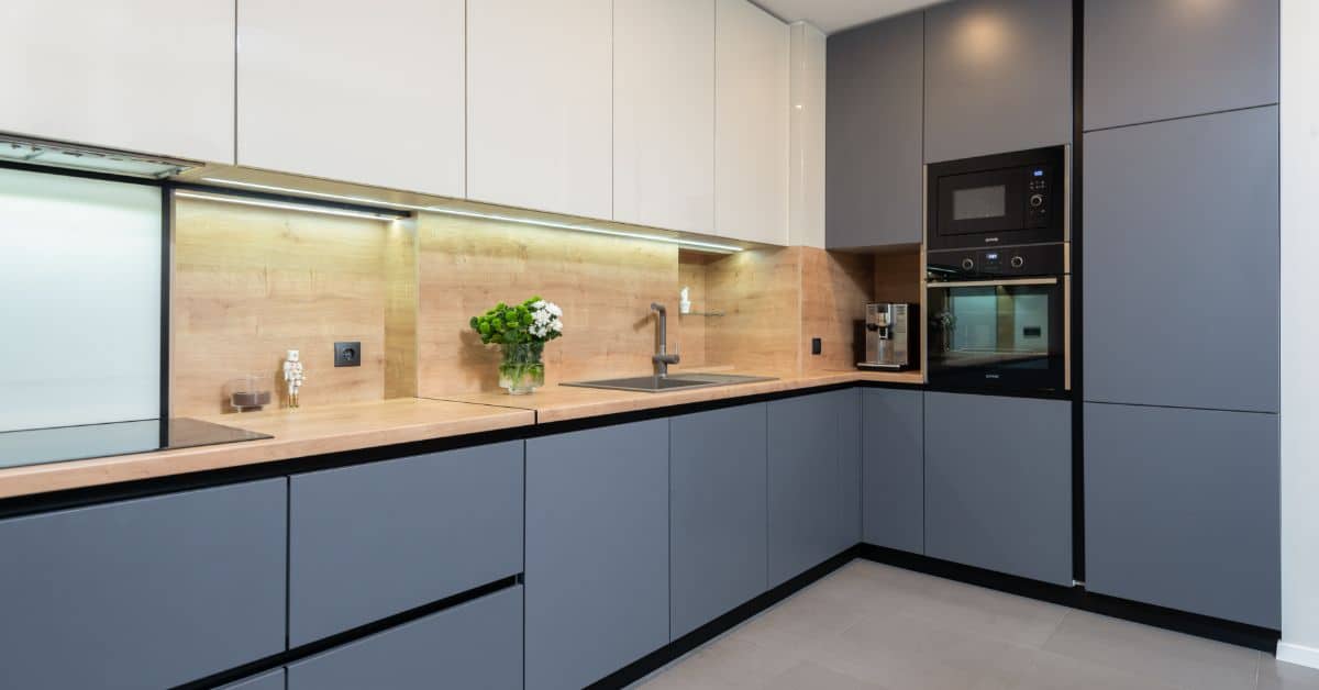 Contemporary kitchen featuring blue cabinets, wooden countertop, and built-in appliances.