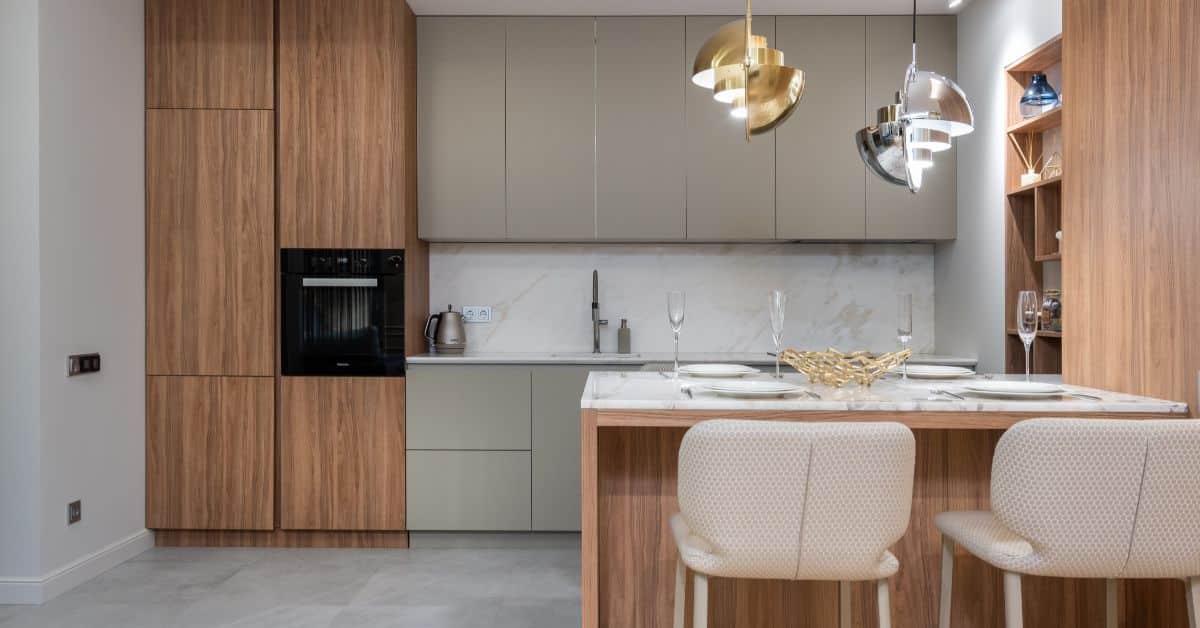 Kitchen with wooden cabinets, marble countertops, and modern lighting fixtures.