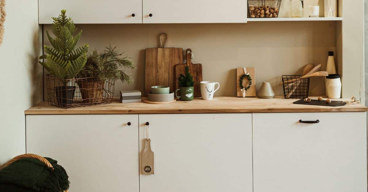 Modern kitchen with wooden accents, plants, and decorative items for a cozy home vibe.