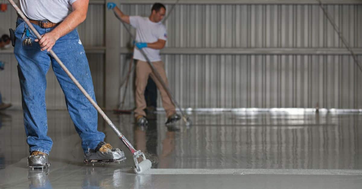 2 Workers Smoothing Out Flooring with Rollers