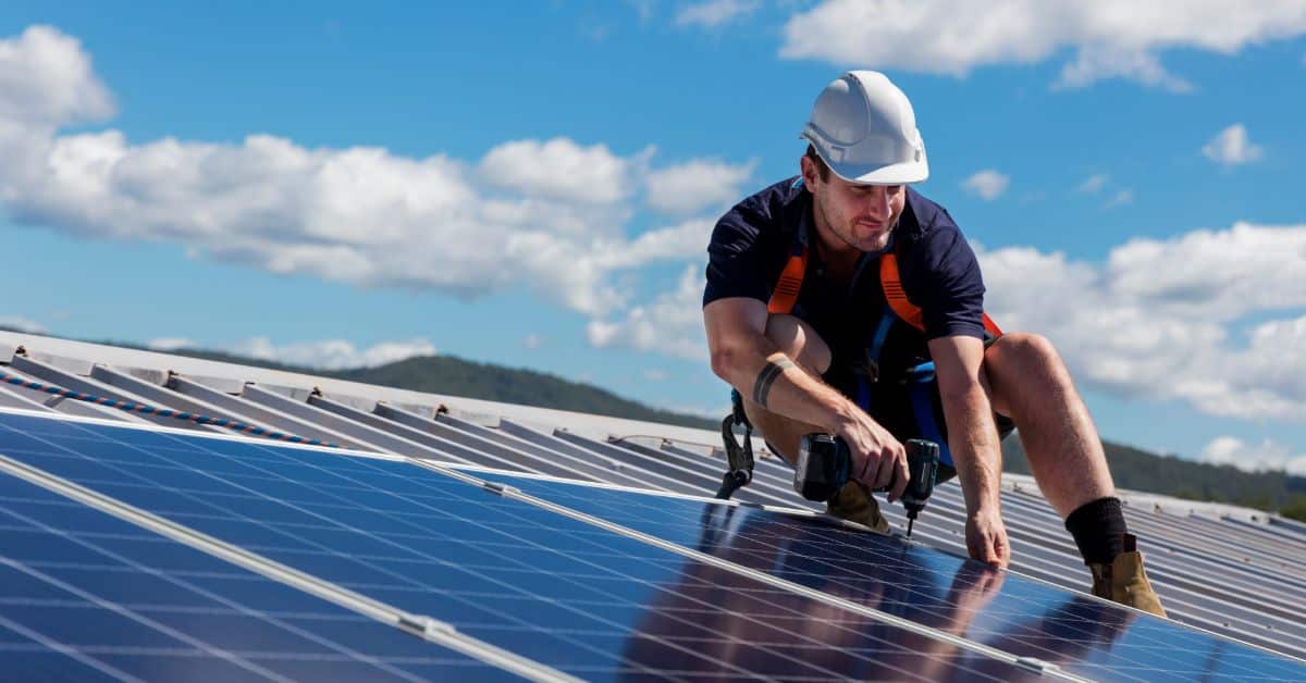 Technician installing solar panels on a rooftop in Cape Town for energy efficiency.