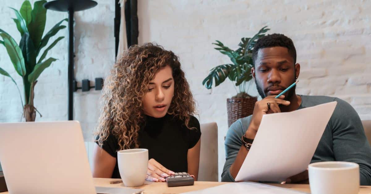 Two people reviewing house plans for a single storey home in South Africa.