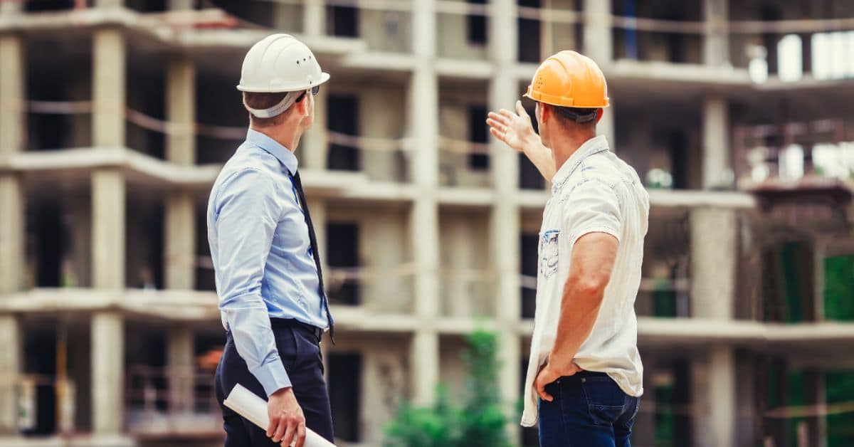 Construction workers discussing building plans at a Cape Town construction site.