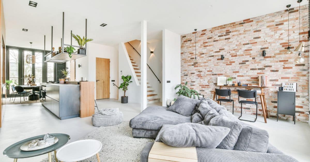 Spacious modern living room with open-plan design and brick accent wall, built by Axio Projects.