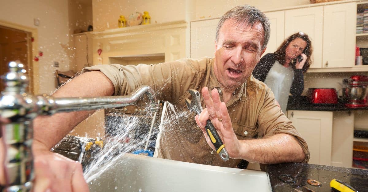 Unclogging a kitchen sink during renovation, highlighting common plumbing errors to prevent.