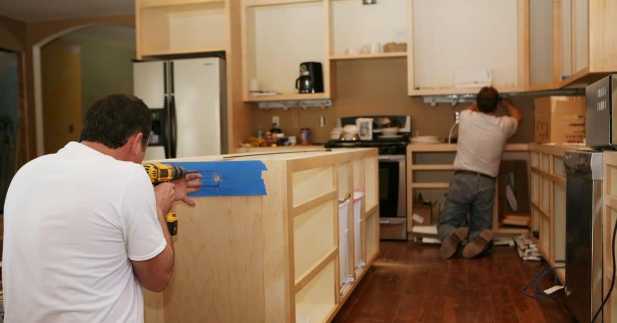 Home remodeling contractors installing kitchen cabinets and countertops.