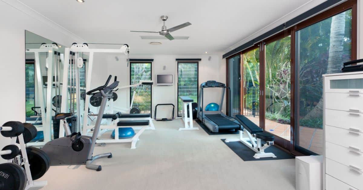 Modern home gym with fitness equipment and large windows for natural light.