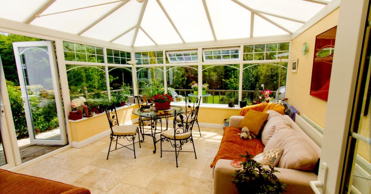 Sunroom with large windows and garden scenery, perfect for relaxing and entertaining. Bright, inviti.
