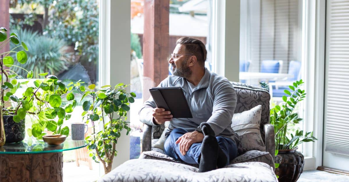 Sunroom - man relaxing on couch with ipad