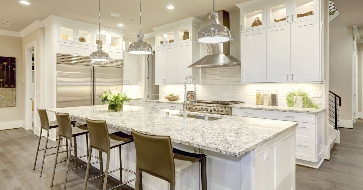 Elegant white kitchen with modern appliances and island, showcasing South African home transformatio.