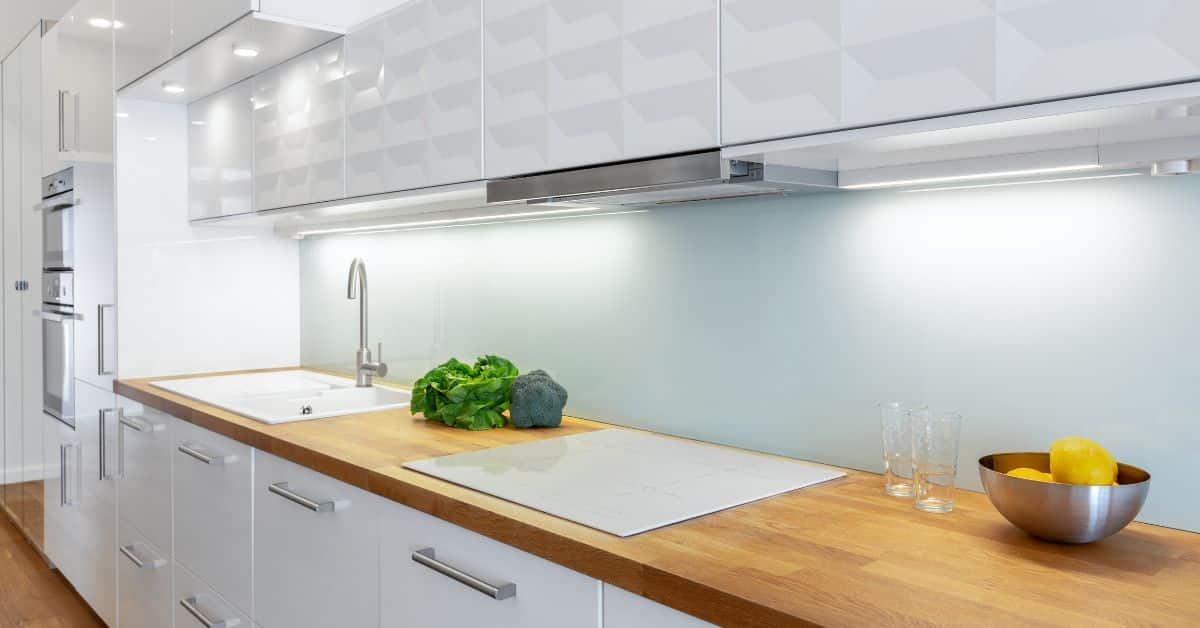 Elegant white kitchen with modern appliances and island, showcasing South African home transformatio.
