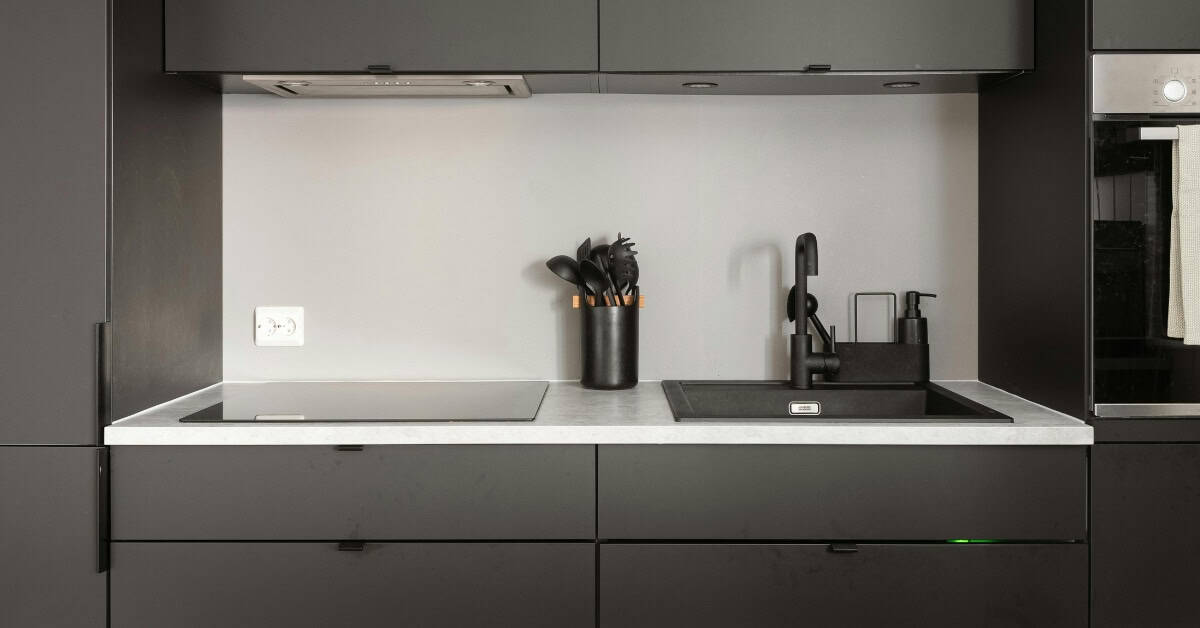 Modern kitchen with sleek black cabinetry and minimalist design.