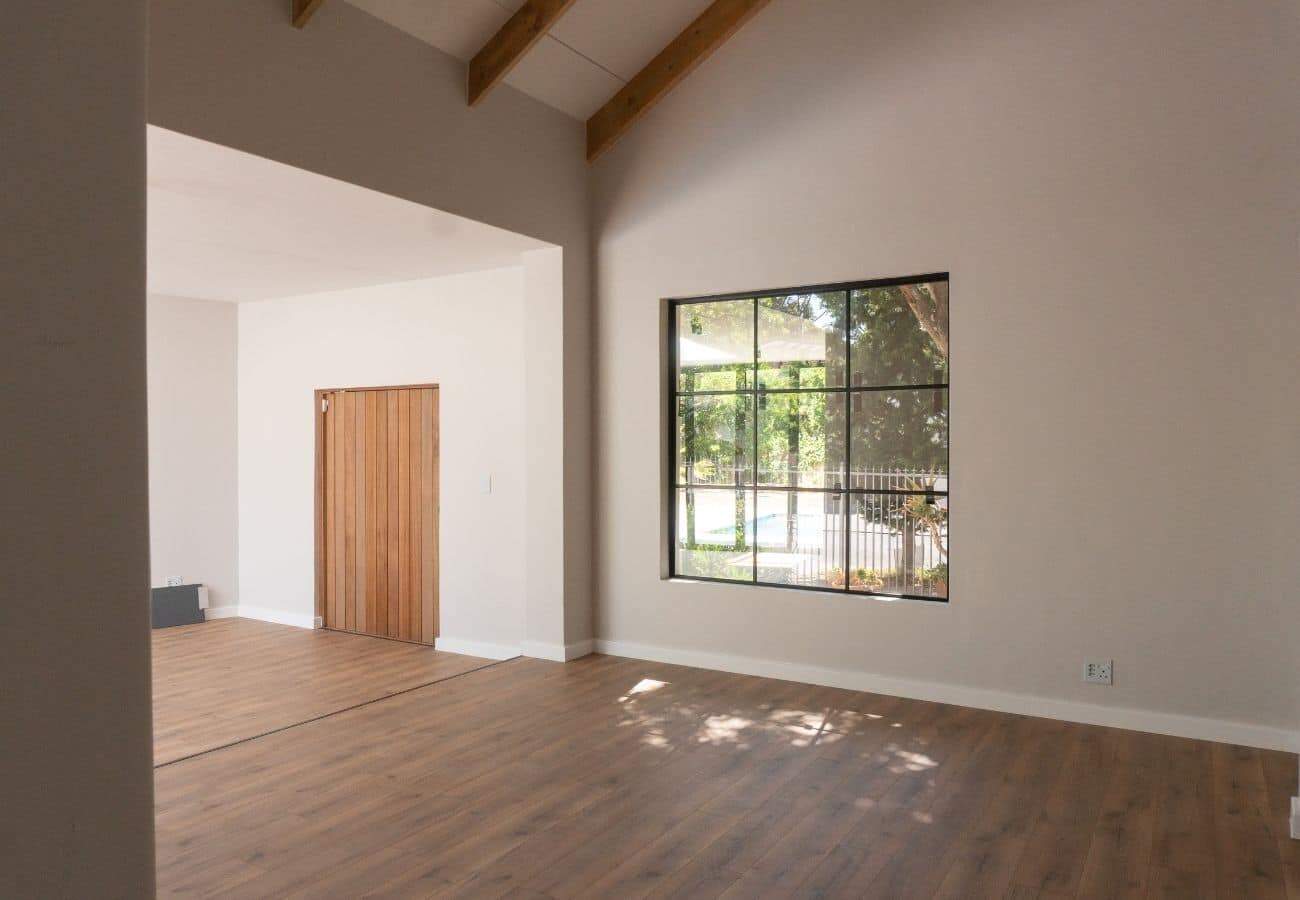 Bright living room with spacious design, natural light, and wooden floors.