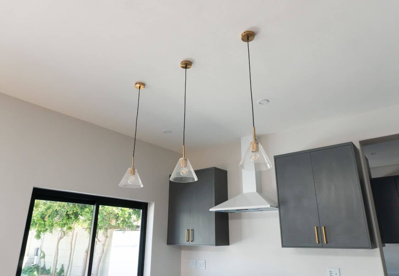 Pendant lighting fixtures over kitchen cabinets for modern interior design.