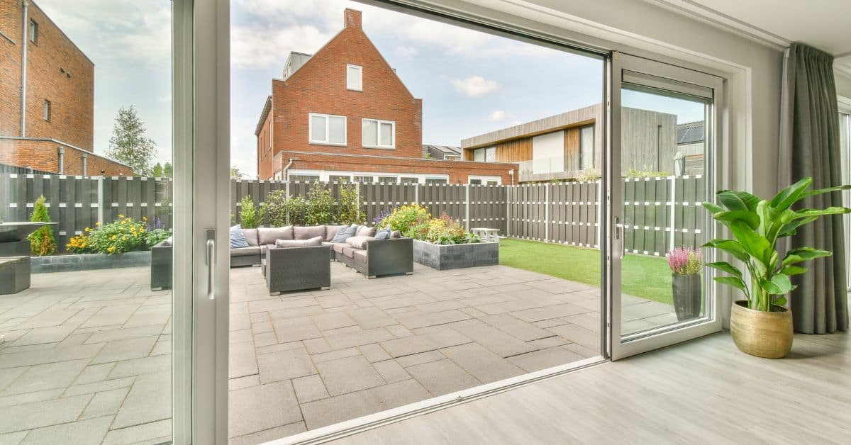 Open Aluminium Doors showing a beautiful patio with a lounge set and green grass