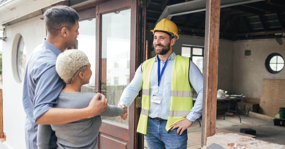 Friendly home builder discussing project details with clients in Cape Town.