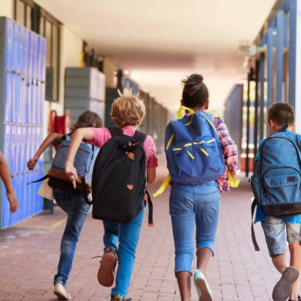 School children walking in corridor at school.