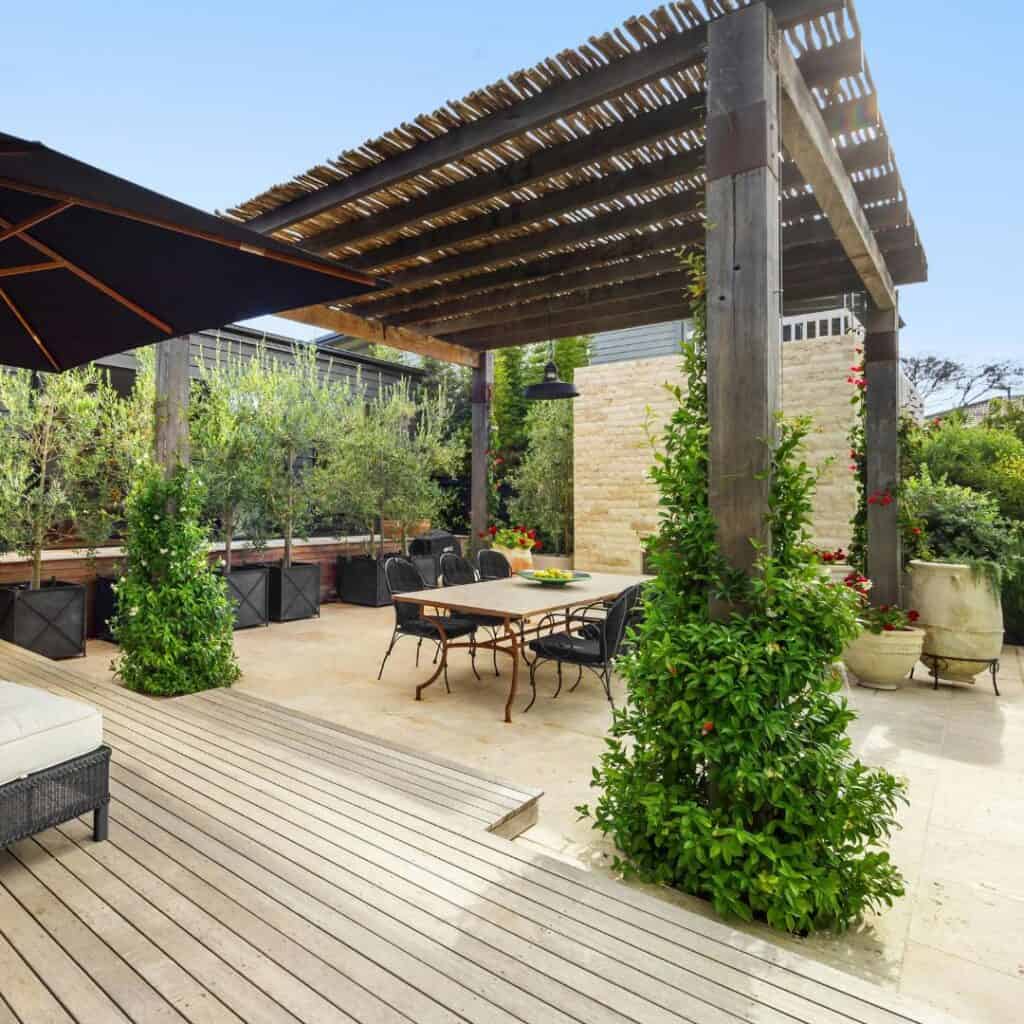 AXIO Projects outdoor patio with pergola and lush greenery.